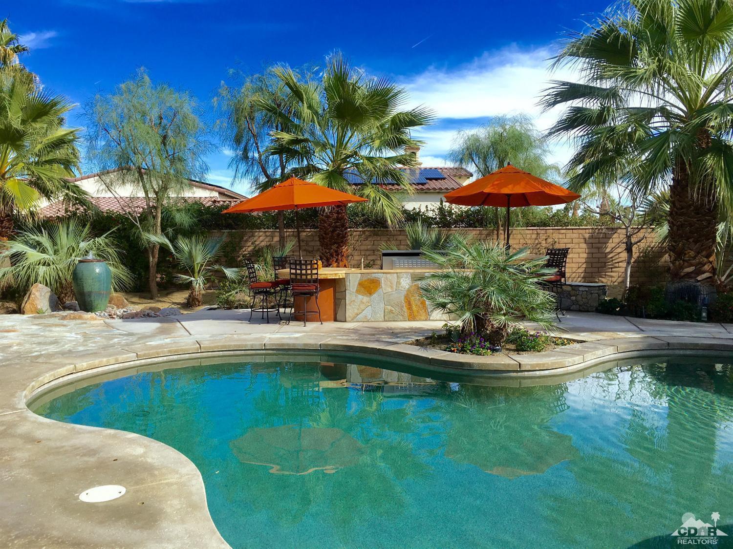40278 Rancho Palmeras Rancho Mirage, CA 92270 - Photo 3 of 68 a view of a swimming pool with a table and chairs under an umbrella
