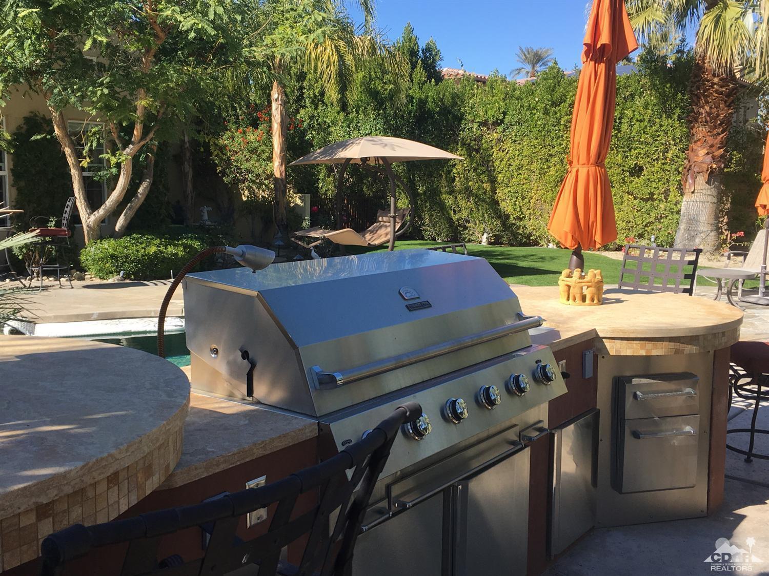 40278 Rancho Palmeras Rancho Mirage, CA 92270 - Photo 50 of 68 a view of a patio with table and chairs under an umbrella with large trees