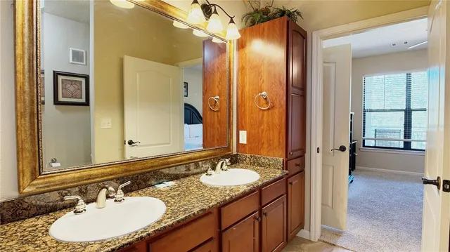 a bathroom with a granite countertop sink and a mirror
