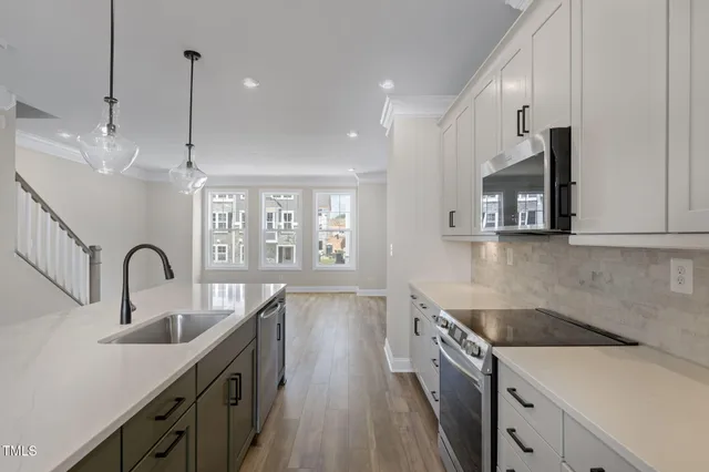 a kitchen with sink stove and wooden floor