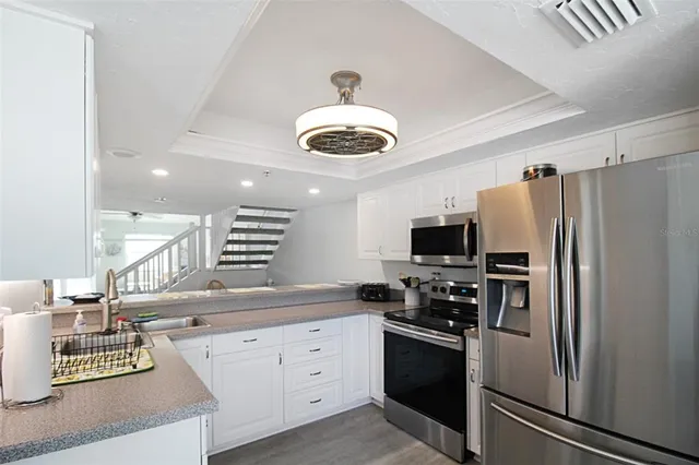 a kitchen with stainless steel appliances a refrigerator sink and stove