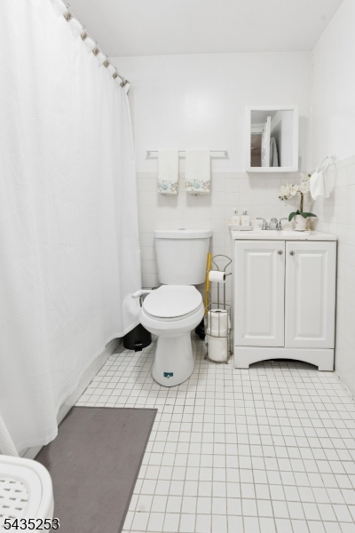 61 Union Street, Unit 2 Lodi, NJ 07644 - Photo 7 of 8 a bathroom with a sink a toilet and a mirror