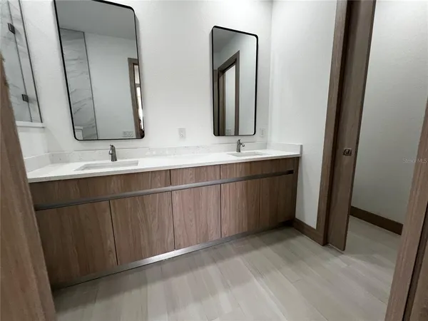 a bathroom with a double vanity sink and mirror