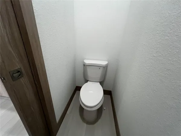 a white toilet sitting in a bathroom next to a sink