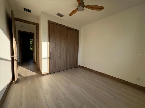 a view of a livingroom with wooden floor and a ceiling fan