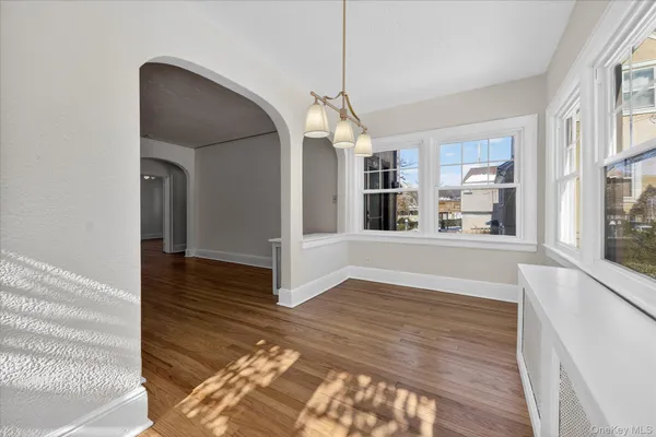 a view of a living room with wooden floor and a kitchen