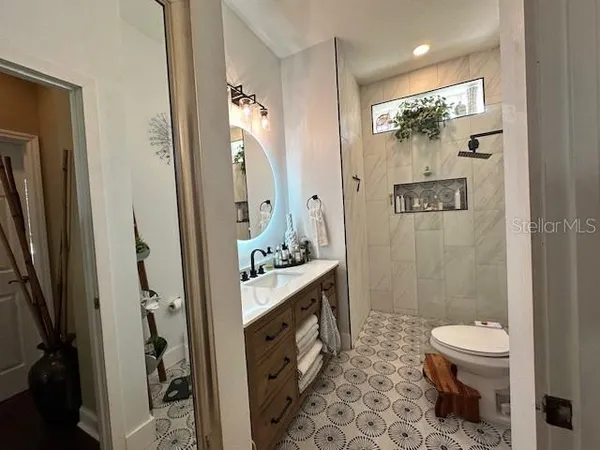 a bathroom with a sink a toilet and shower
