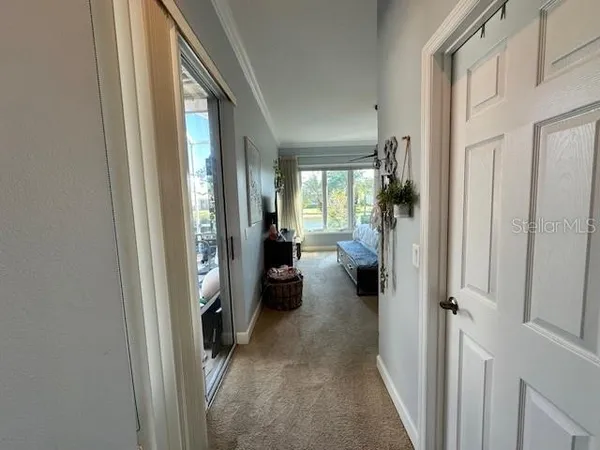 a view of a hallway with a livingroom and furniture