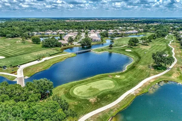 an aerial view of a residential houses with outdoor space and river