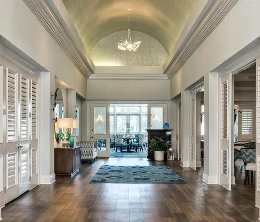 a view of a hallway with furniture and a chandelier