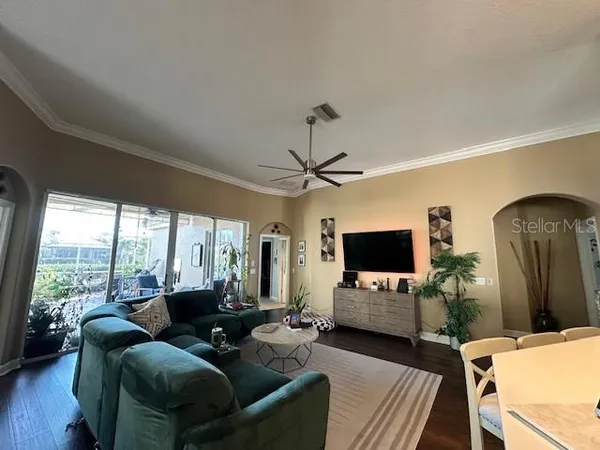 a living room with furniture flat screen tv and a large window