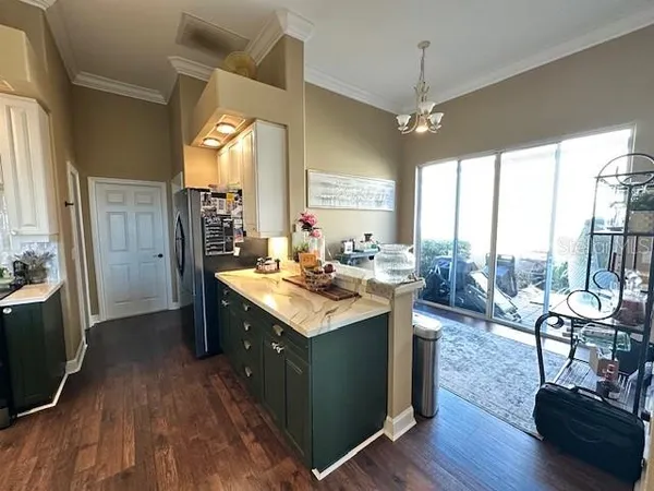 a kitchen with granite countertop a stove refrigerator and wooden floor
