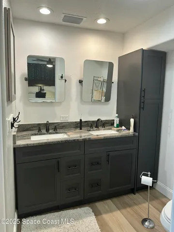 a bathroom with a double vanity sink and mirror