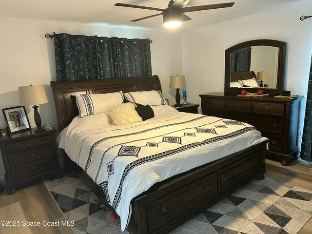 a bedroom with bed and wooden floor