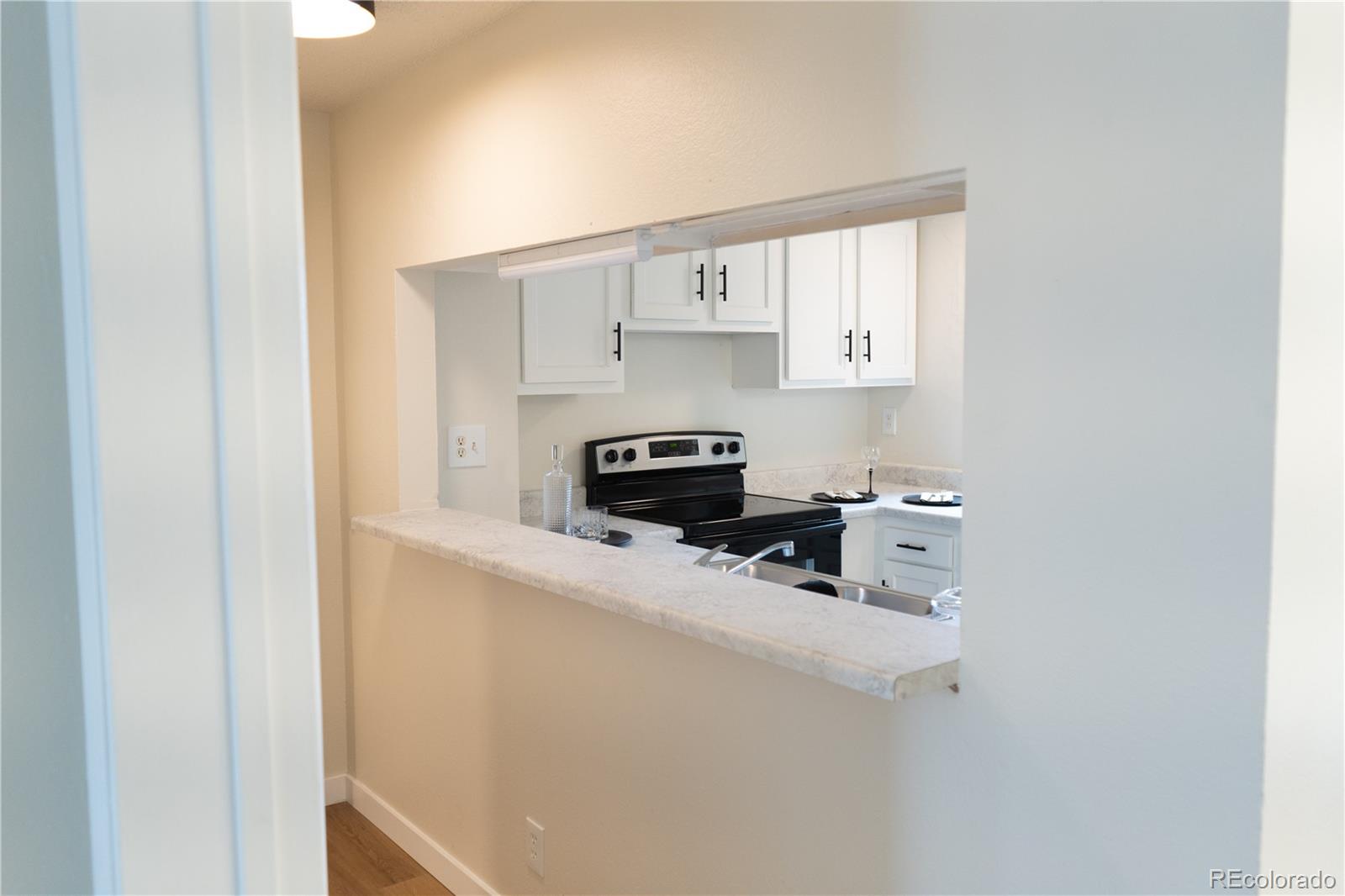 3073 West Center Avenue, Unit C Denver, CO 80219 - Photo 16 of 34 a kitchen with a refrigerator and a stove
