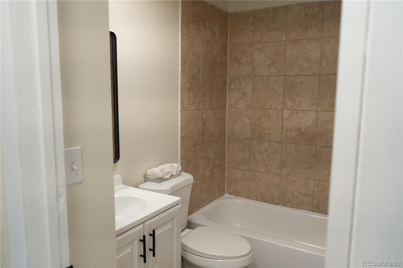 3073 West Center Avenue, Unit C Denver, CO 80219 - Photo 26 of 34 a bathroom with a sink a toilet and shower