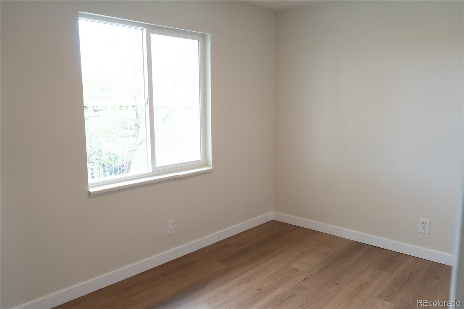3073 West Center Avenue, Unit C Denver, CO 80219 - Photo 28 of 34 an empty room with wooden floor and windows