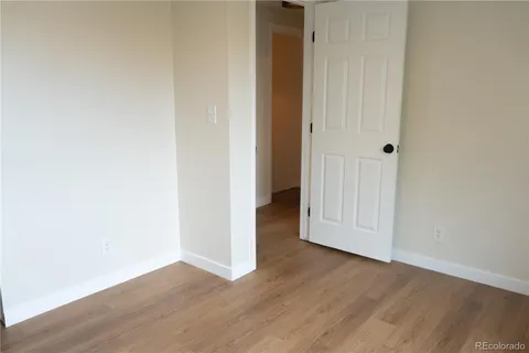 an empty room with wooden floor and closet