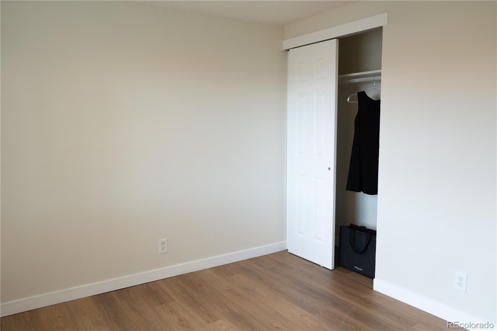 3073 West Center Avenue, Unit C Denver, CO 80219 - Photo 30 of 34 an empty room with wooden floor and closet
