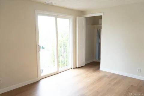 an empty room with wooden floor and closet