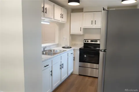 a kitchen with stainless steel appliances a stove and white cabinets