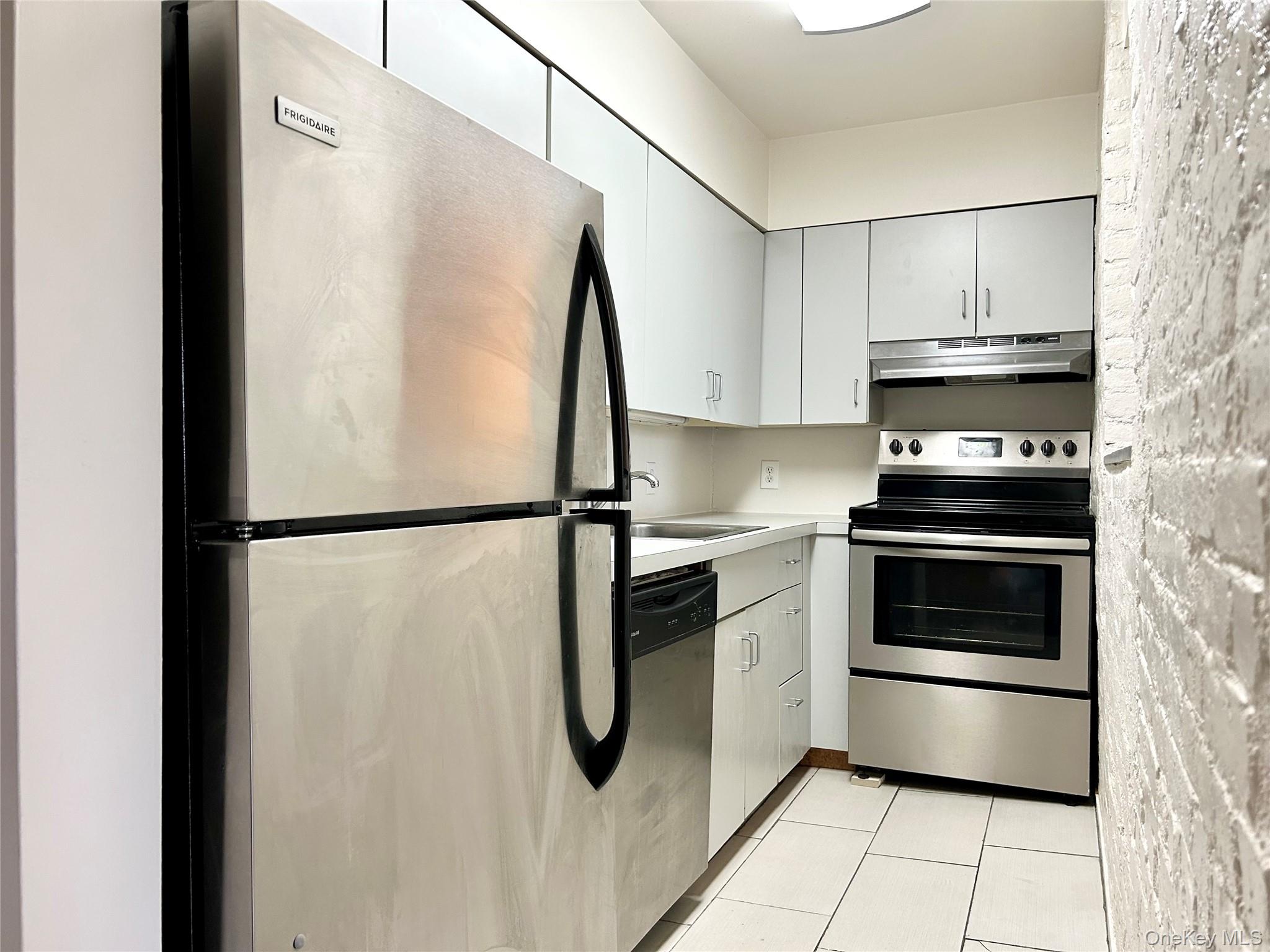 110 Mill Street, Unit 4E Poughkeepsie, NY 12601 - Photo 5 of 7 a kitchen with stainless steel appliances a refrigerator stove and microwave