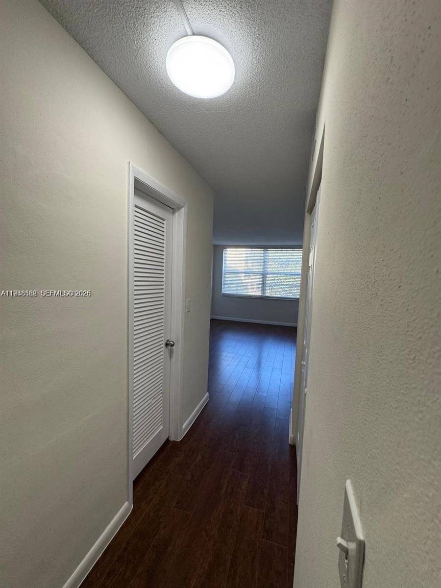 1201 Northeast 191st Street, Unit G313 Miami, FL 33179 - Photo 12 of 15 an empty room with wooden floor and windows