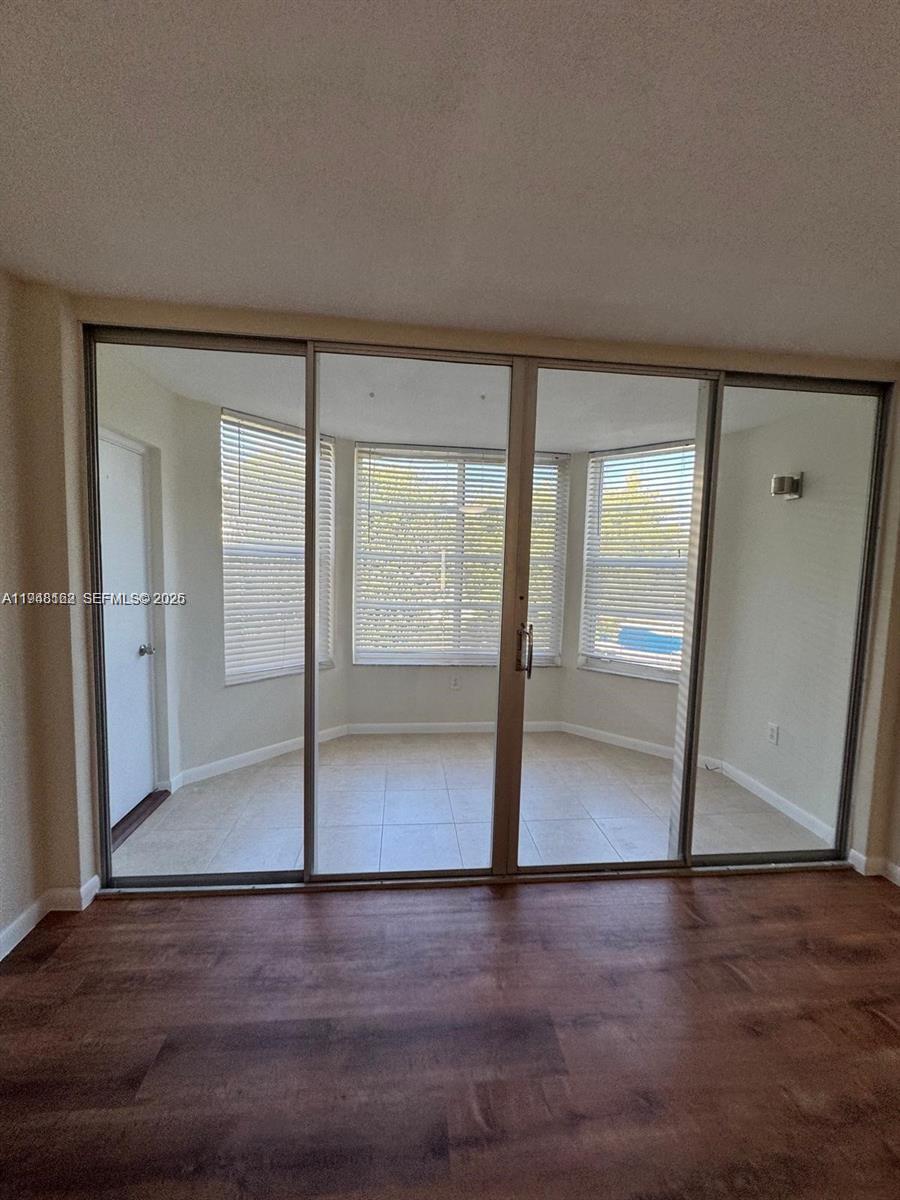 1201 Northeast 191st Street, Unit G313 Miami, FL 33179 - Photo 15 of 15 an empty room with wooden floor and entrance
