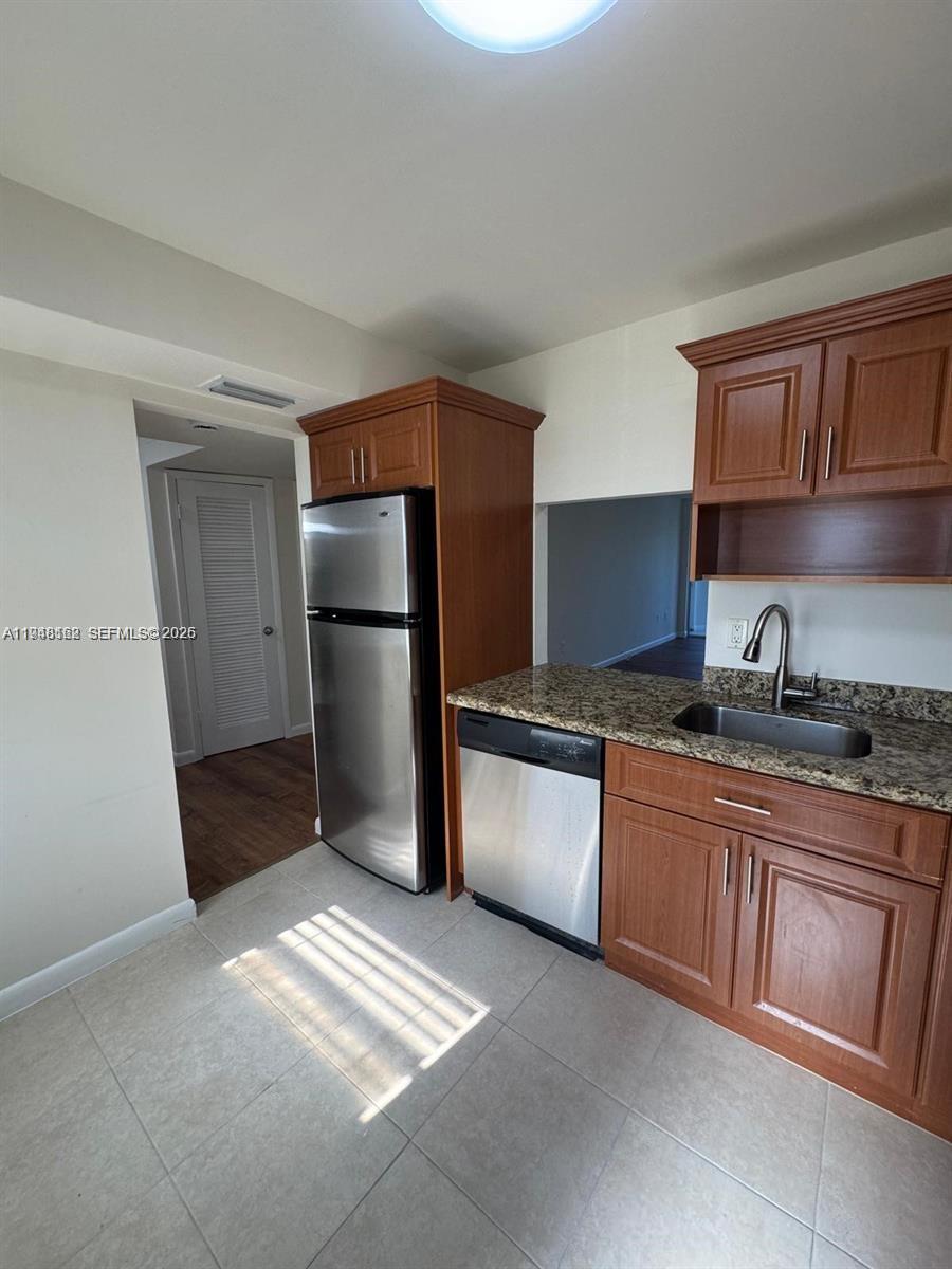 1201 Northeast 191st Street, Unit G313 Miami, FL 33179 - Photo 4 of 15 a kitchen with stainless steel appliances granite countertop a refrigerator and a sink