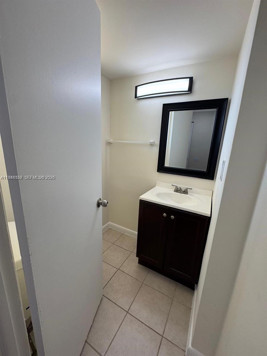 1201 Northeast 191st Street, Unit G313 Miami, FL 33179 - Photo 9 of 15 a bathroom with a sink and mirror