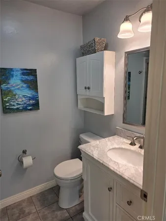 a bathroom with a granite countertop sink mirror vanity and toilet