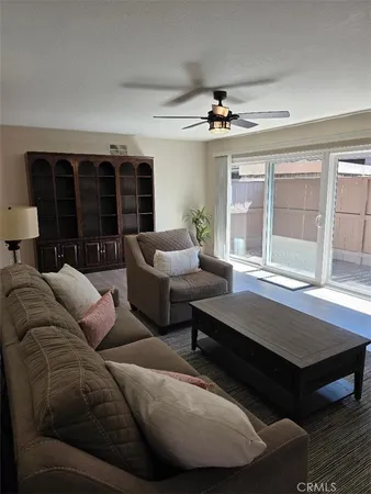 a living room with furniture ceiling fan and a window