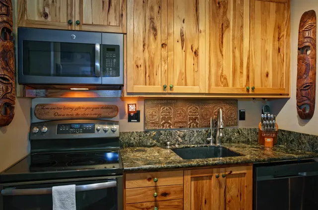 a kitchen with granite countertop a stove and a microwave
