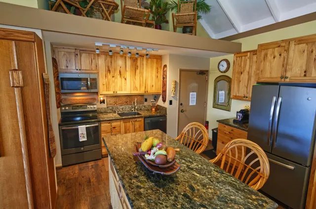 a kitchen with stainless steel appliances granite countertop a refrigerator and a stove top oven