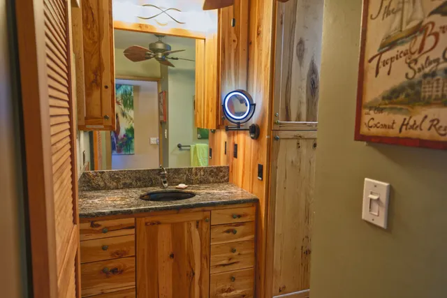 a bathroom with a granite countertop sink and a mirror