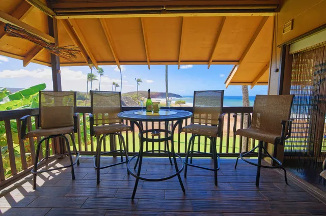 a view of a patio with table and chairs under an umbrella