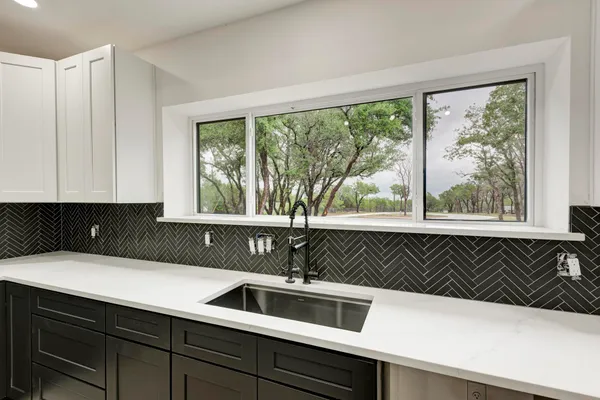 a kitchen with a sink and large window