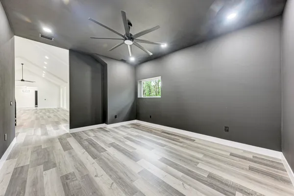a view of empty room with window and ceiling fan