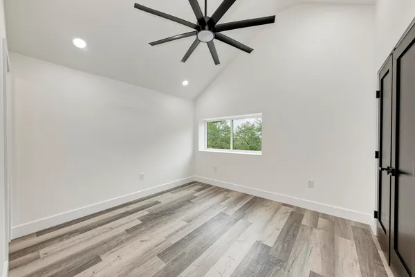 an empty room with a window and a fan