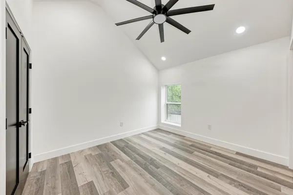 an empty room with windows and fan