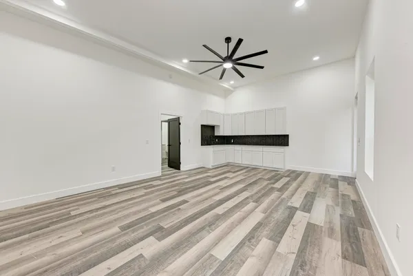 a view of a livingroom with a ceiling fan and wooden floor