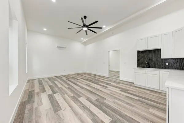 a view of a livingroom with an empty space & a ceiling fan