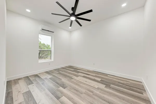 an empty room with a window and a fan