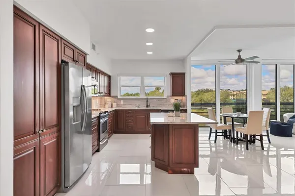 a kitchen with stainless steel appliances kitchen island granite countertop a refrigerator and a stove top oven
