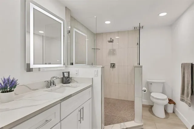 a bathroom with a sink a toilet and shower