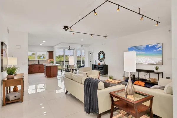 a living room with furniture kitchen view and a chandelier