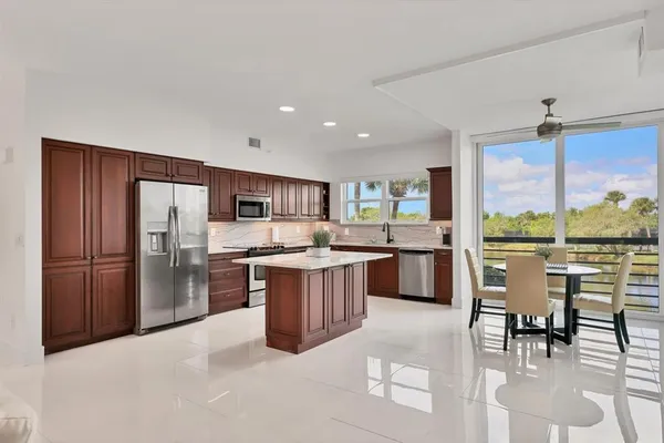 a kitchen with stainless steel appliances kitchen island granite countertop a refrigerator and cabinets