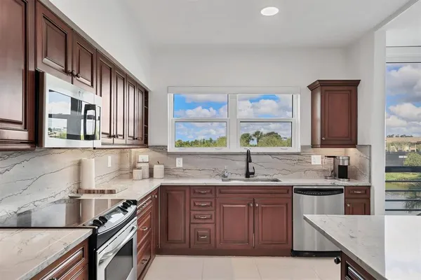 a kitchen with stainless steel appliances granite countertop a sink stove and cabinets