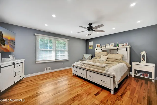 a spacious bedroom with a bed and a flat screen tv