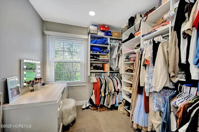 a view of walk in closet with clothes and shoes